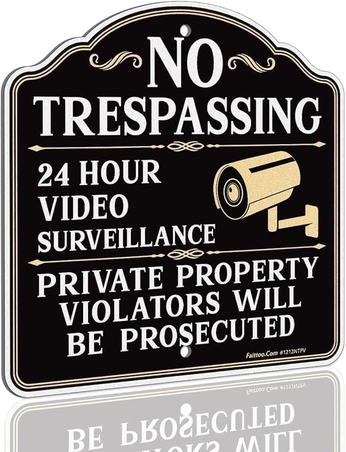 A sign that says no trespassing, 2 4 hour video surveillance and private property violators will be prosecuted.