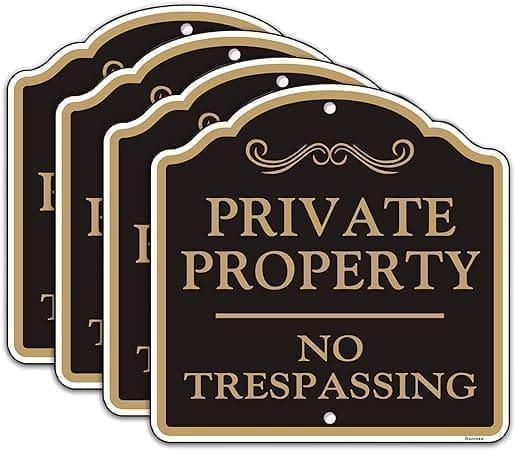 A set of four signs that say private property no trespassing.