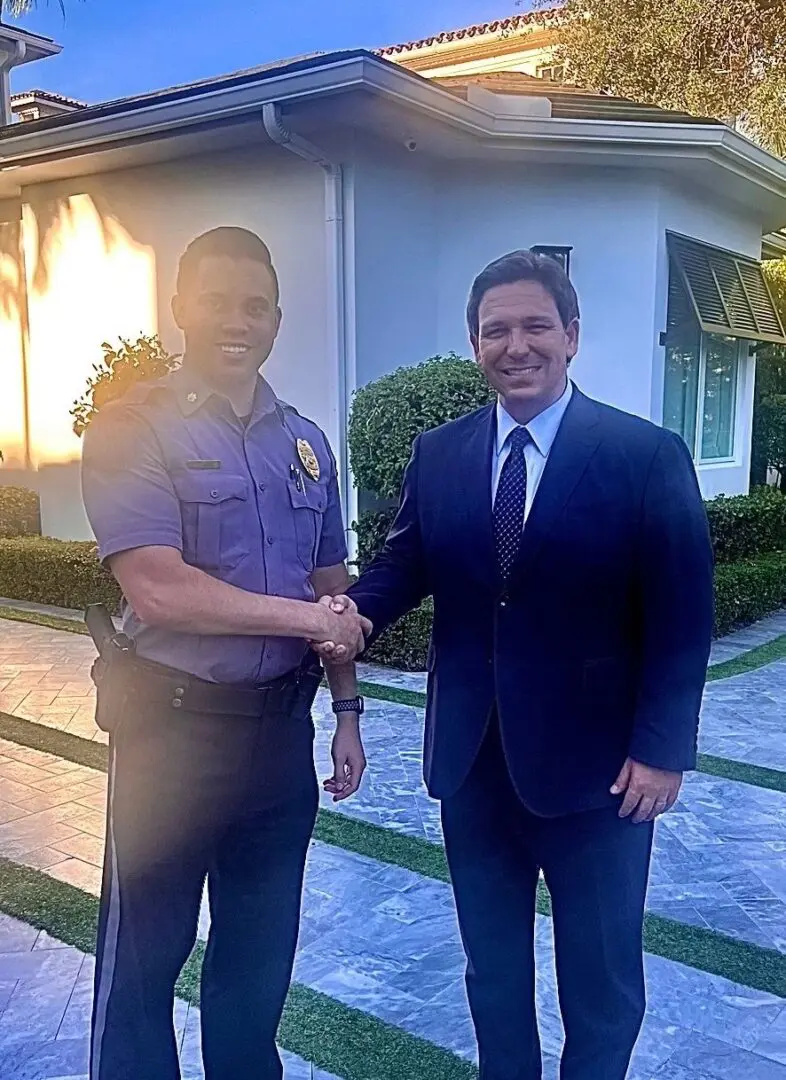 A man in uniform shaking hands with another person.