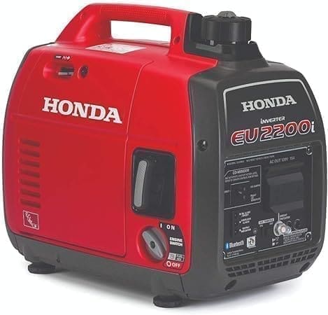 A red and black honda generator is sitting on the ground.